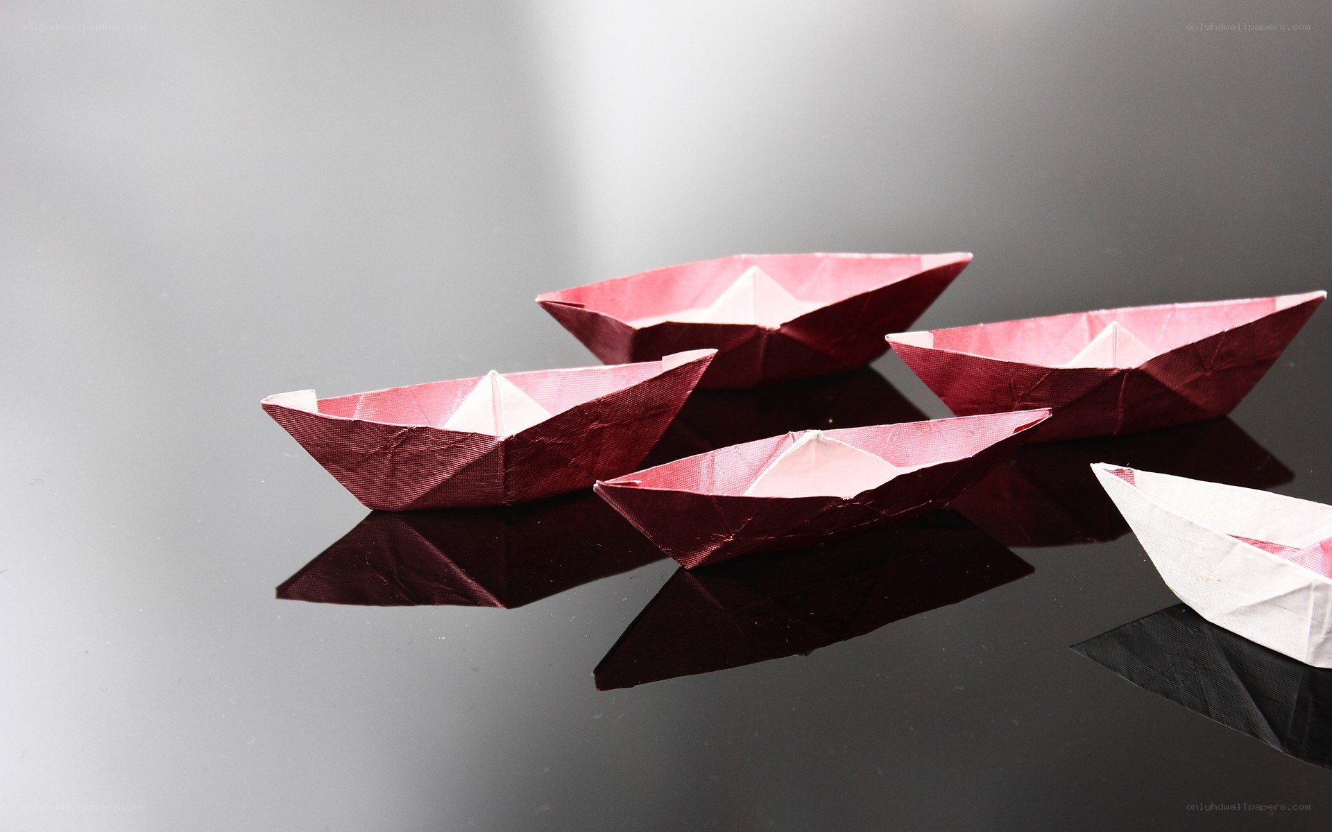 origami boats on reflective surface