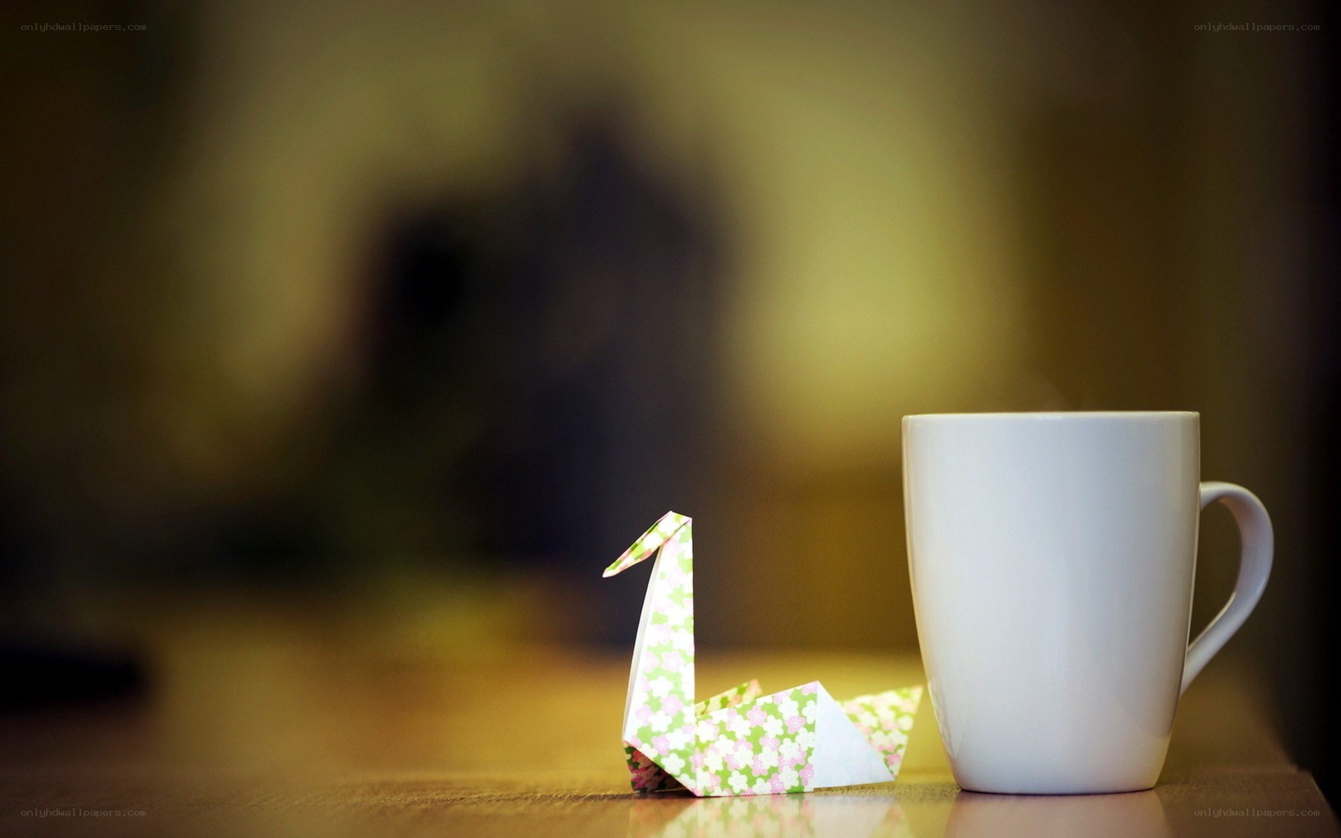 Origami crane beside a mug