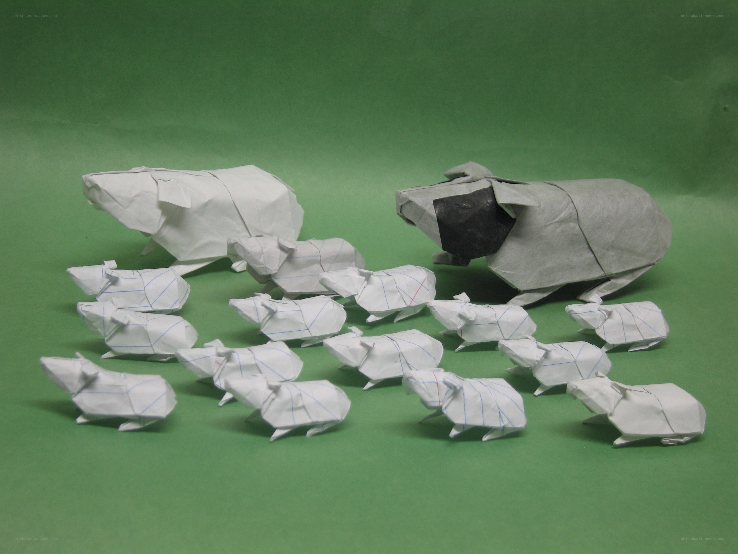 Origami pigs on green