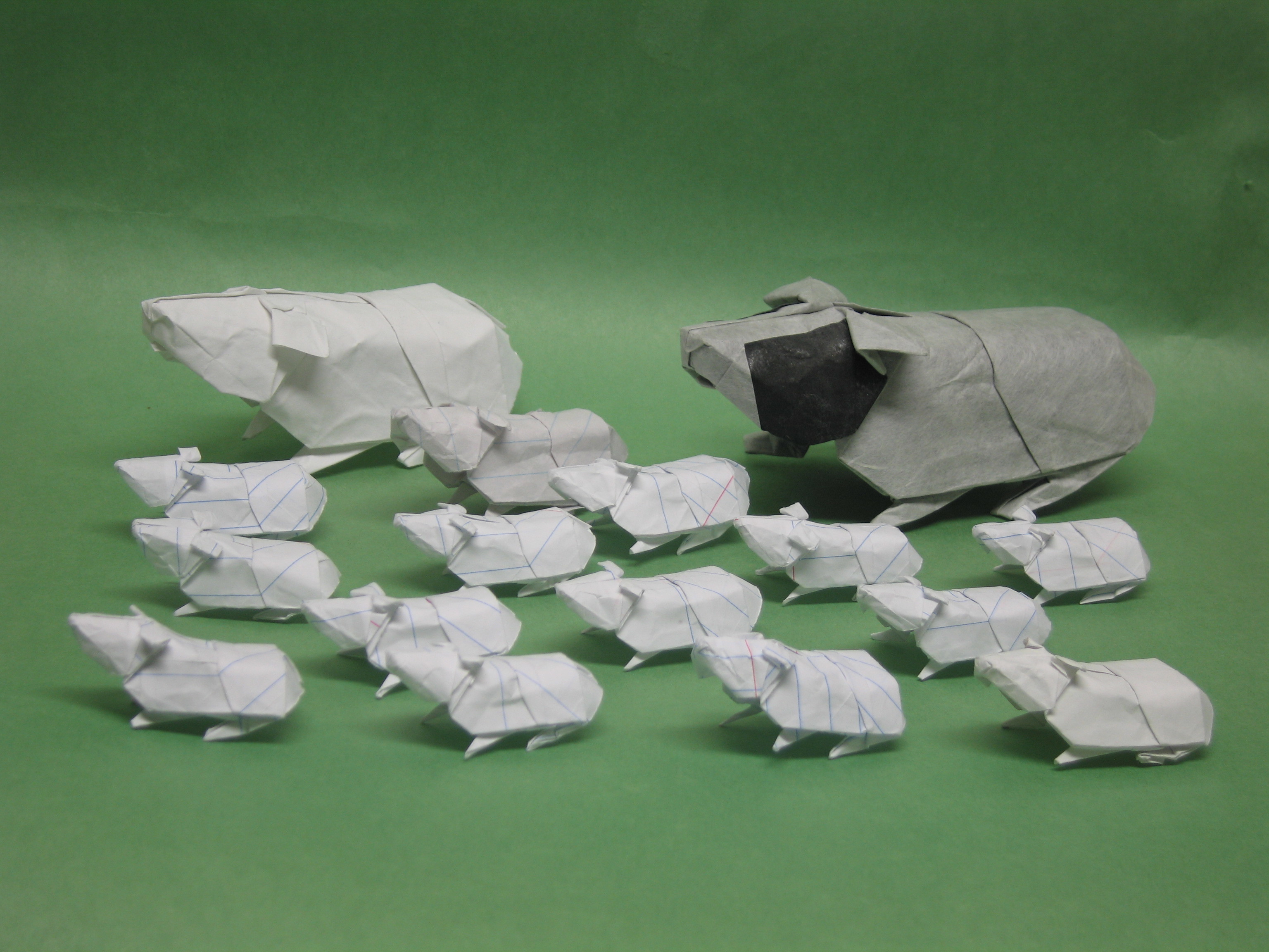 Origami pigs on green