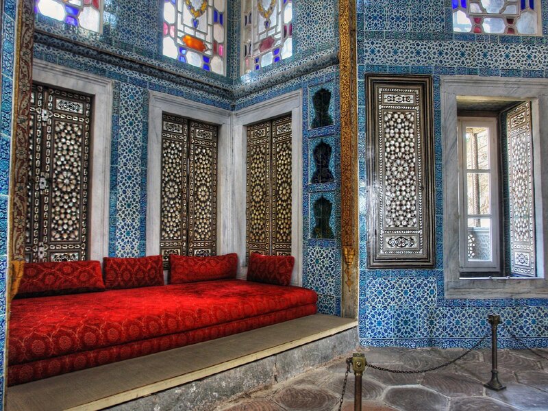 ornate blue-tiled room with red seating