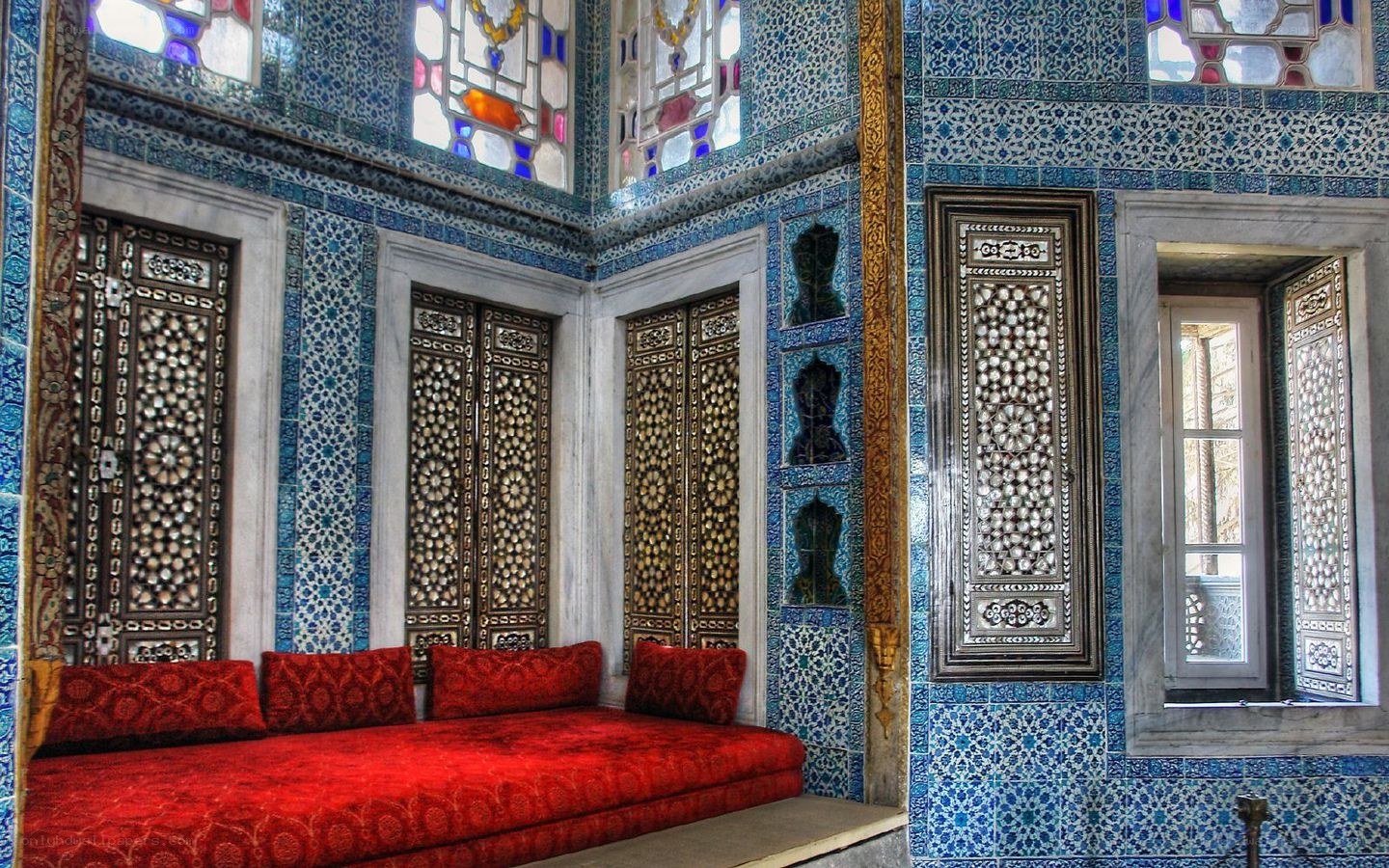 ornate blue-tiled room with red seating