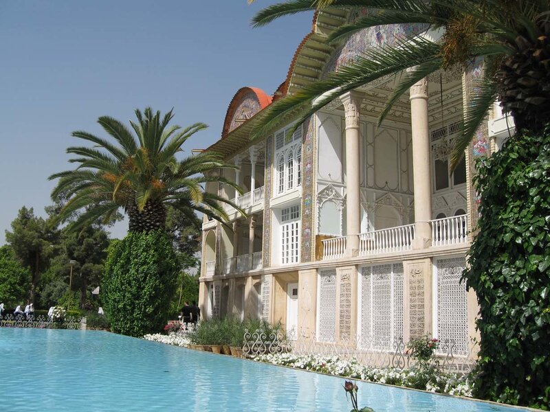 ornate building with pool and palm trees