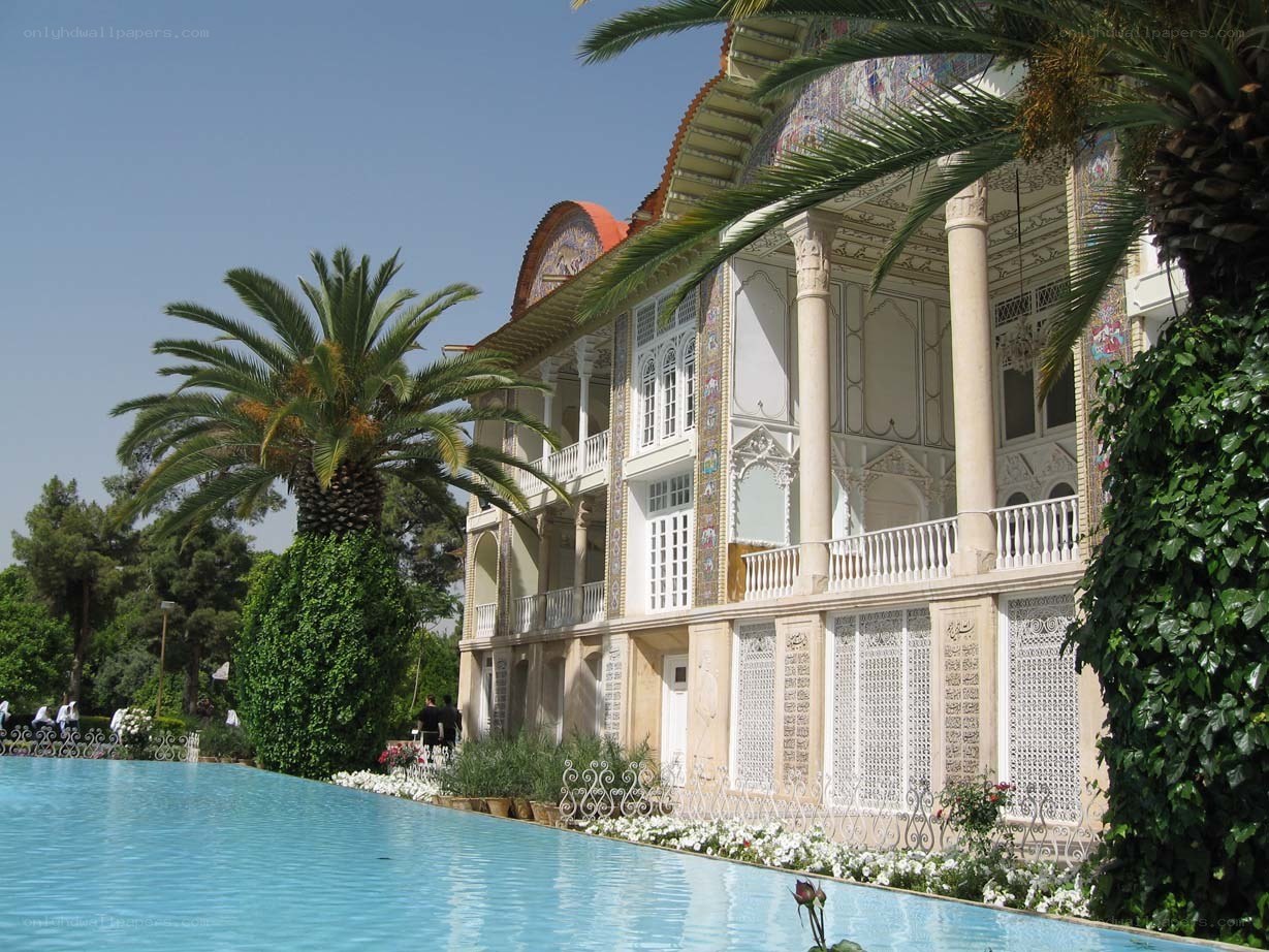 ornate building with pool and palm trees