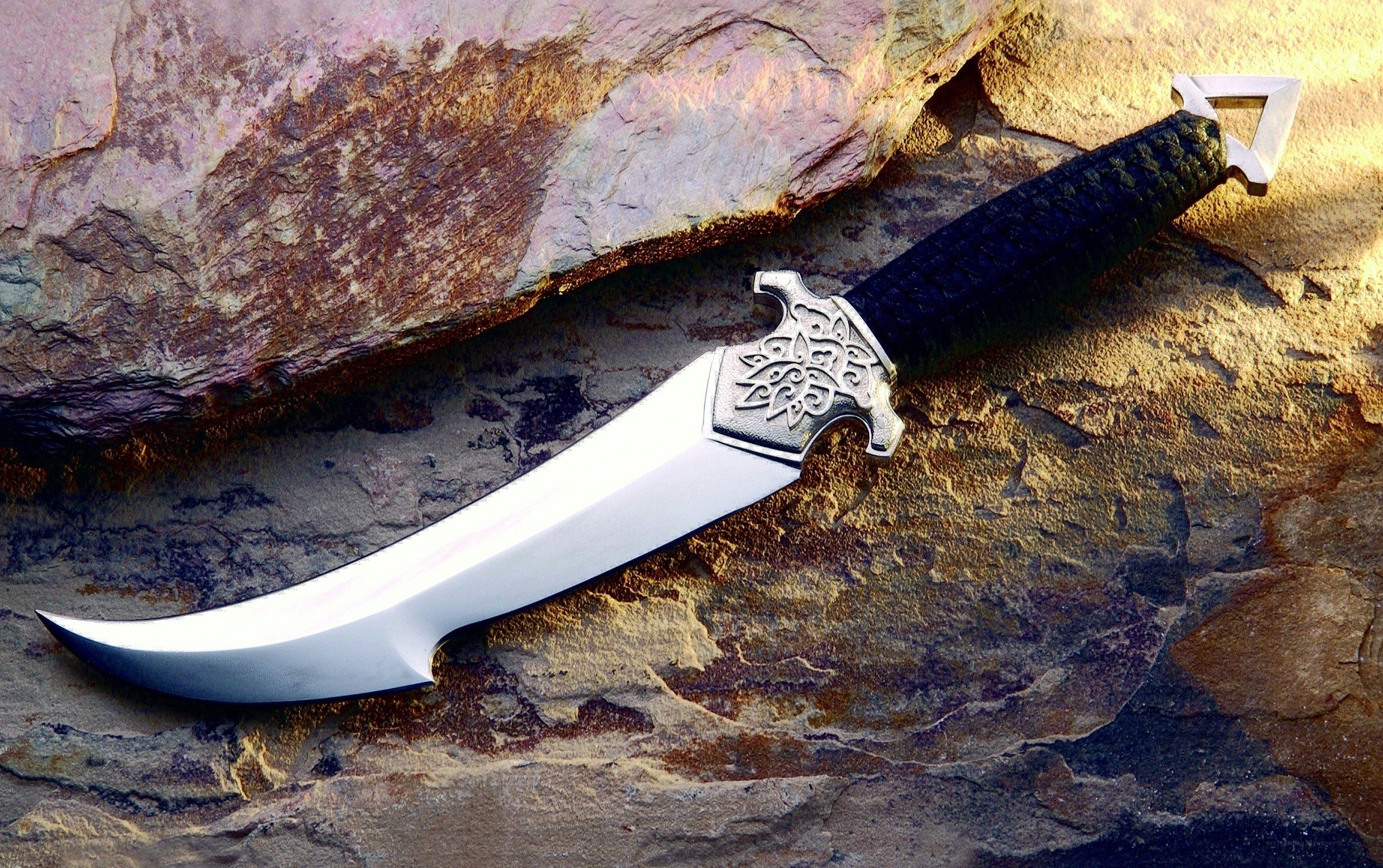 ornate curved dagger on rock