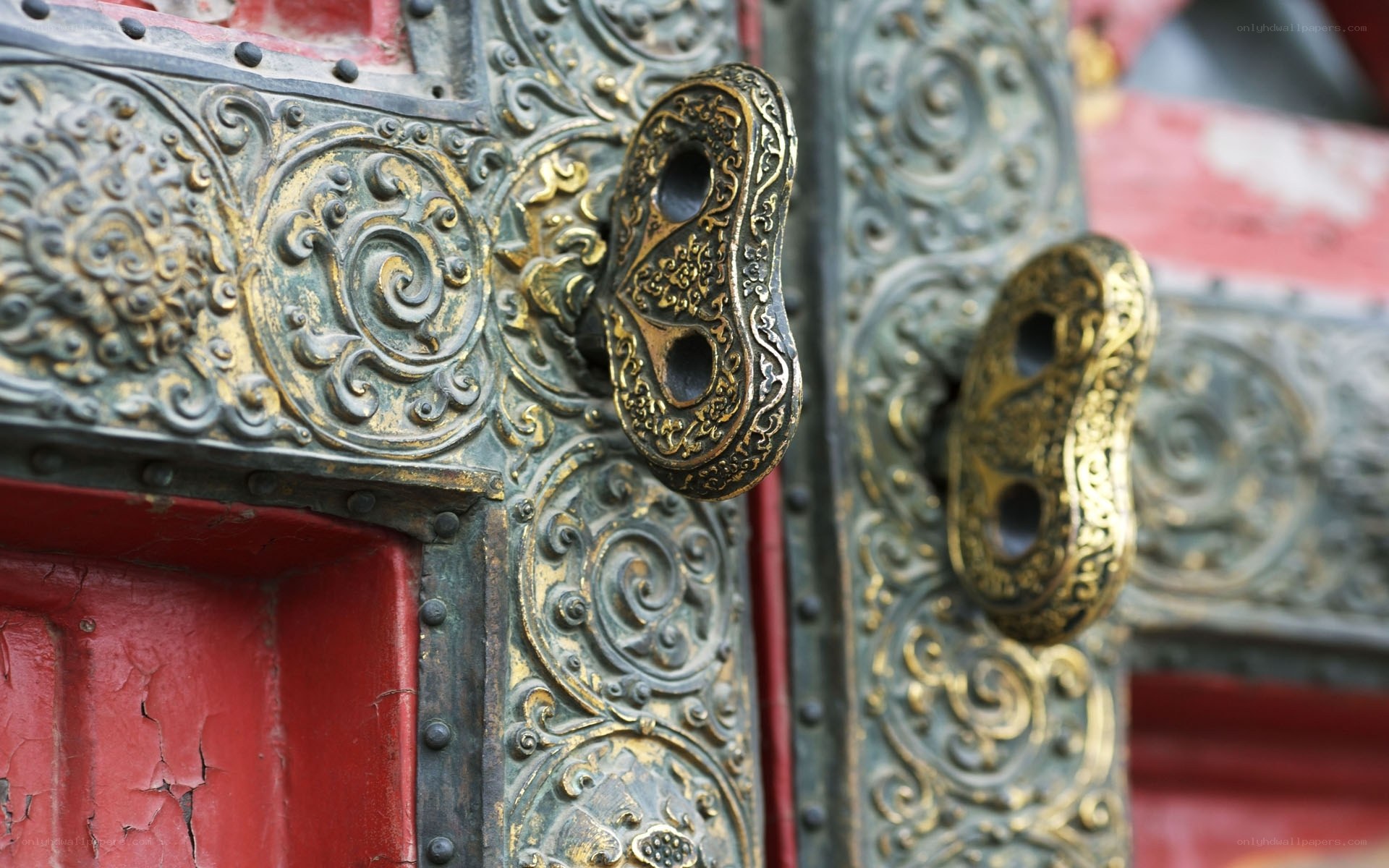 ornate door handles on red door