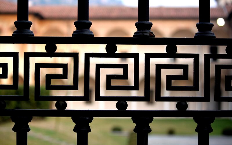 ornate iron fence with building in background