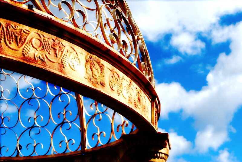 ornate metal arch against blue sky