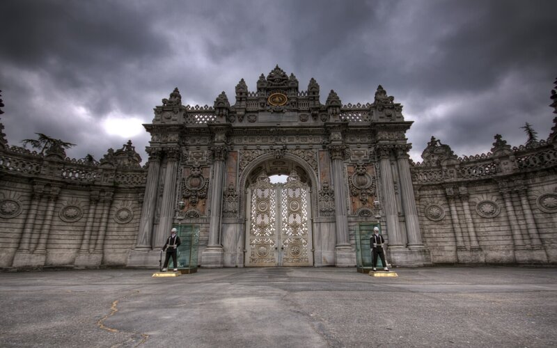 ornate palace gate under stormy sky
