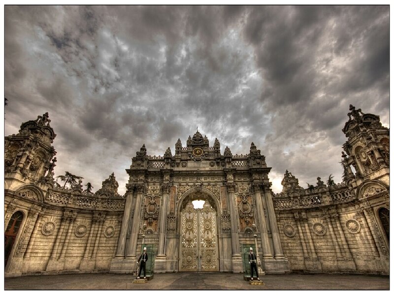 Ornate palace gate under stormy sky