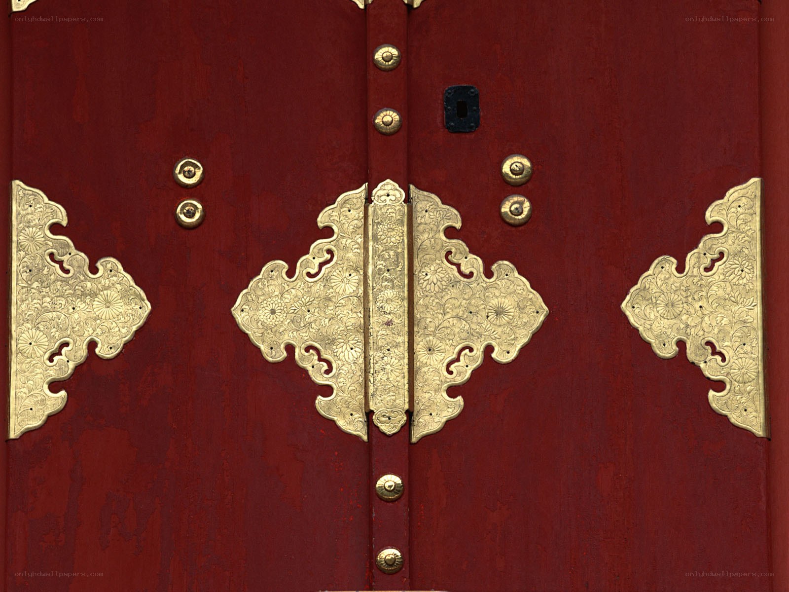 ornate red door with brass hardware