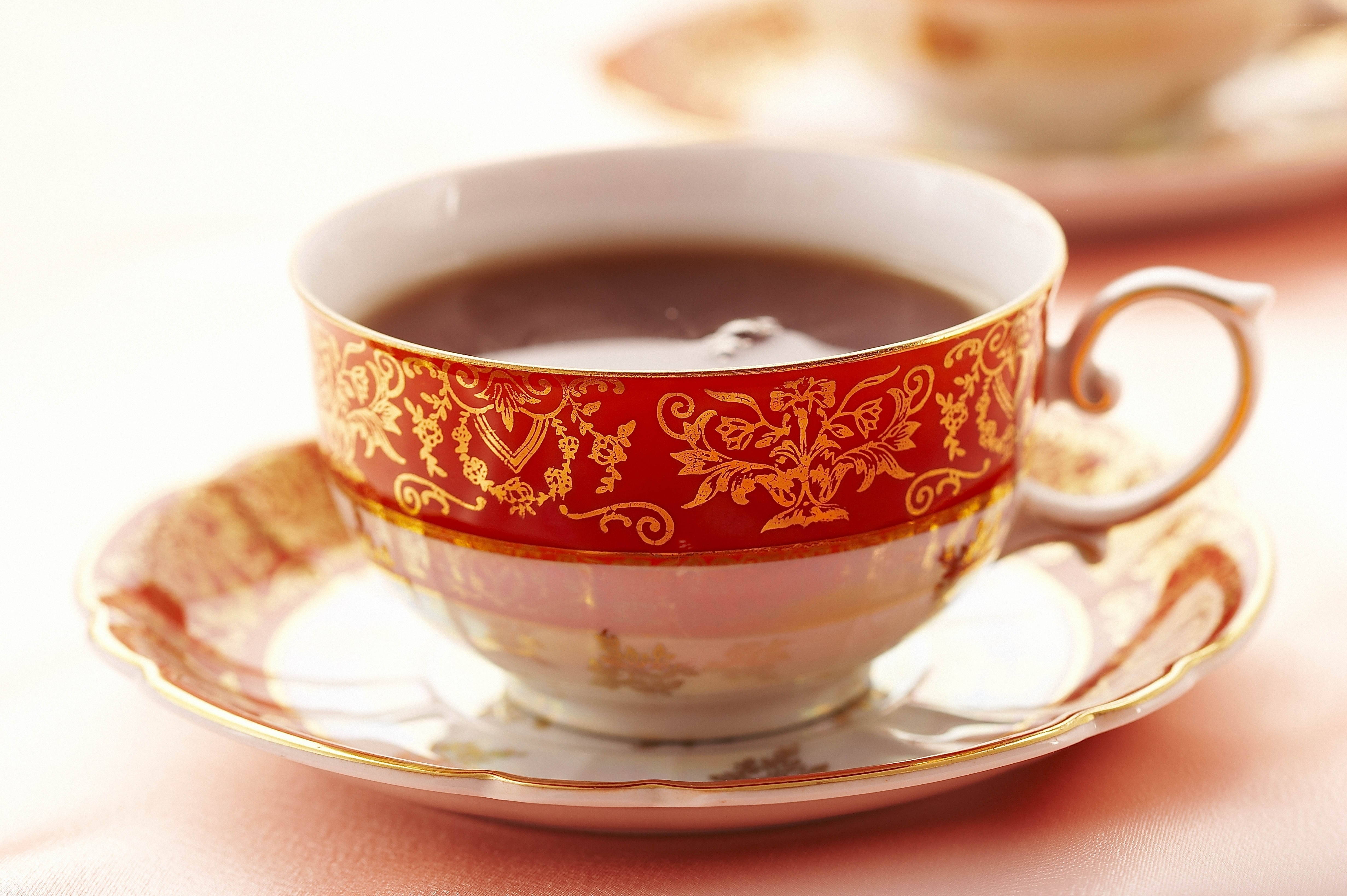 ornate tea cup with dark liquid