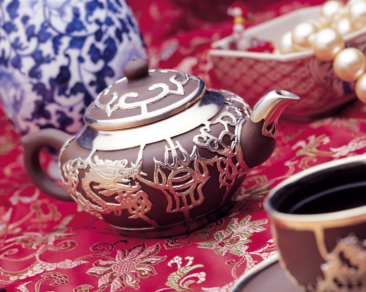ornate teapot on red cloth