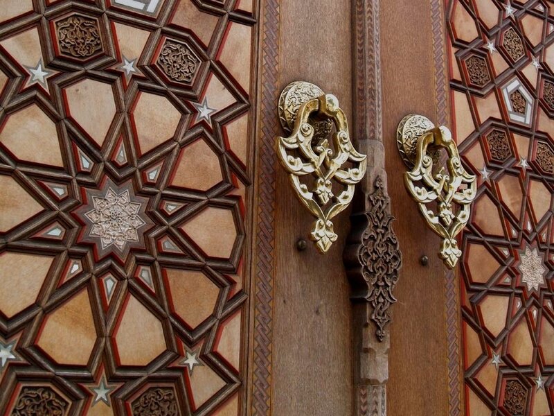 ornate wooden door with metal handles
