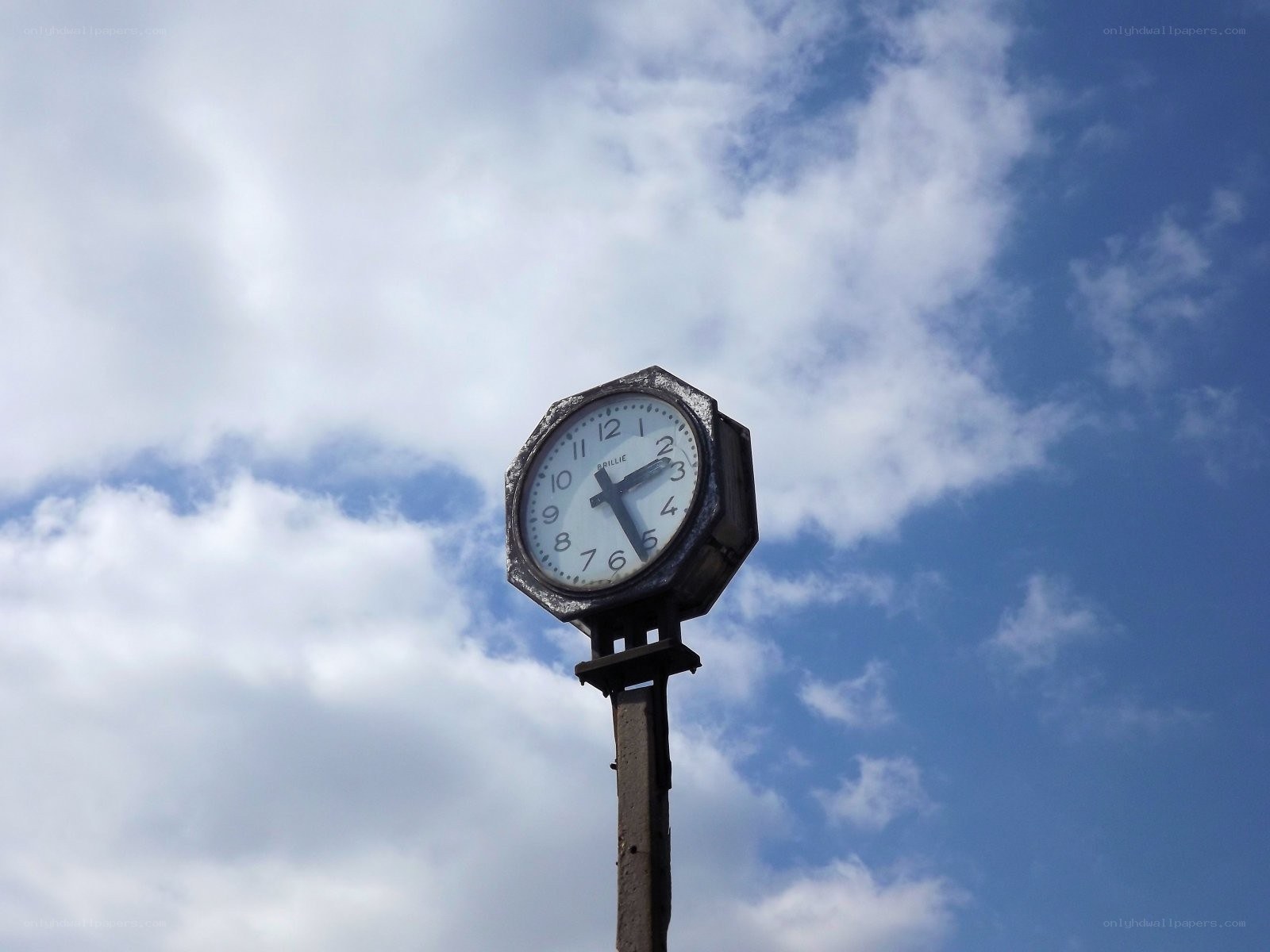 Outdoor clock against cloudy sky