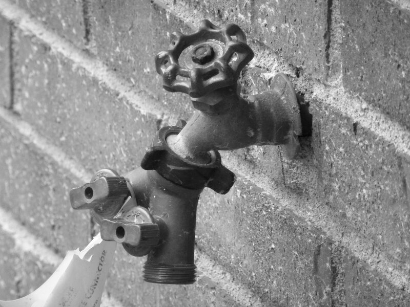 Outdoor faucet on brick wall