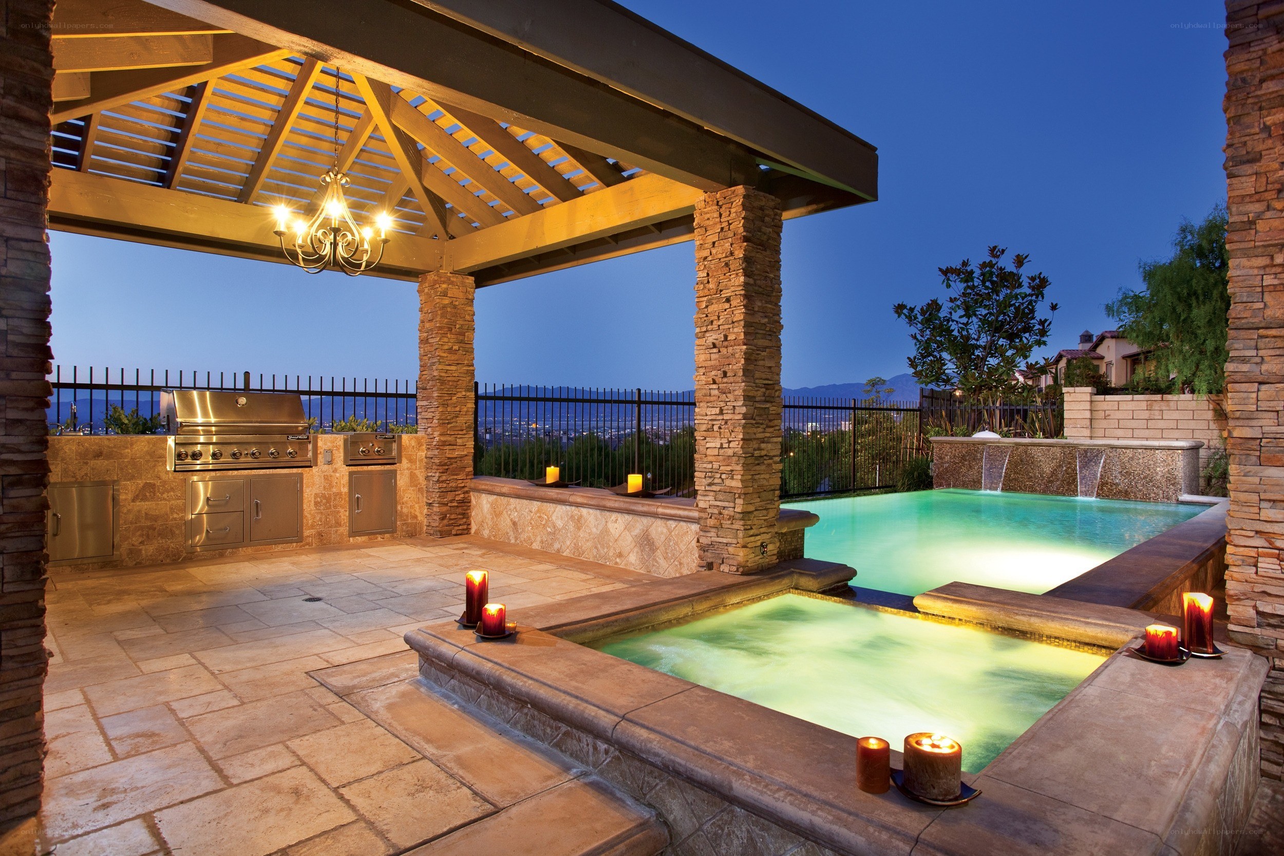 Outdoor kitchen and pool at dusk
