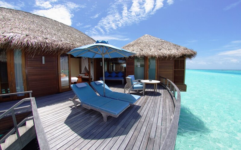 Overwater bungalow with lounge chairs