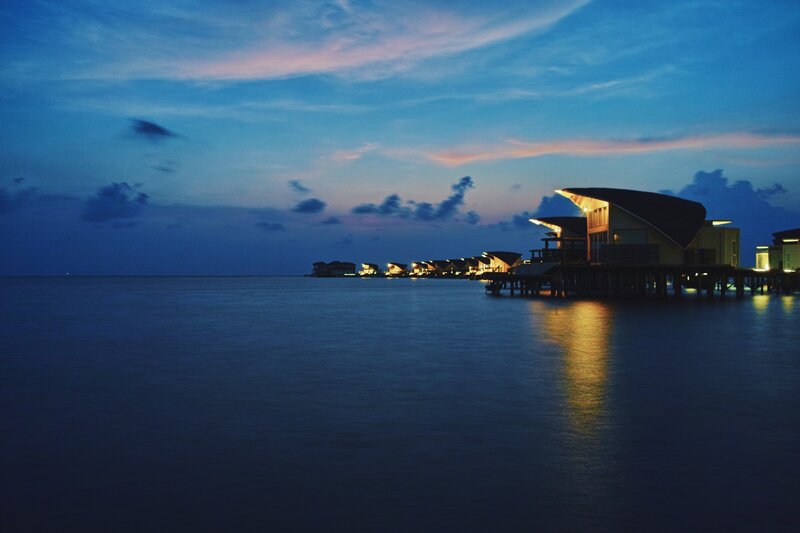 Overwater Bungalows at Dusk — Blue, Serene, Night, Photograph, Ocean, Sky