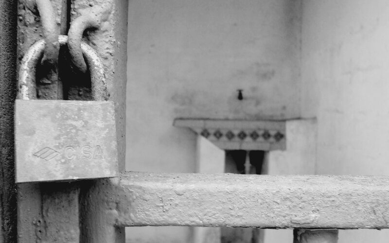 Padlocked gate with sink in background
