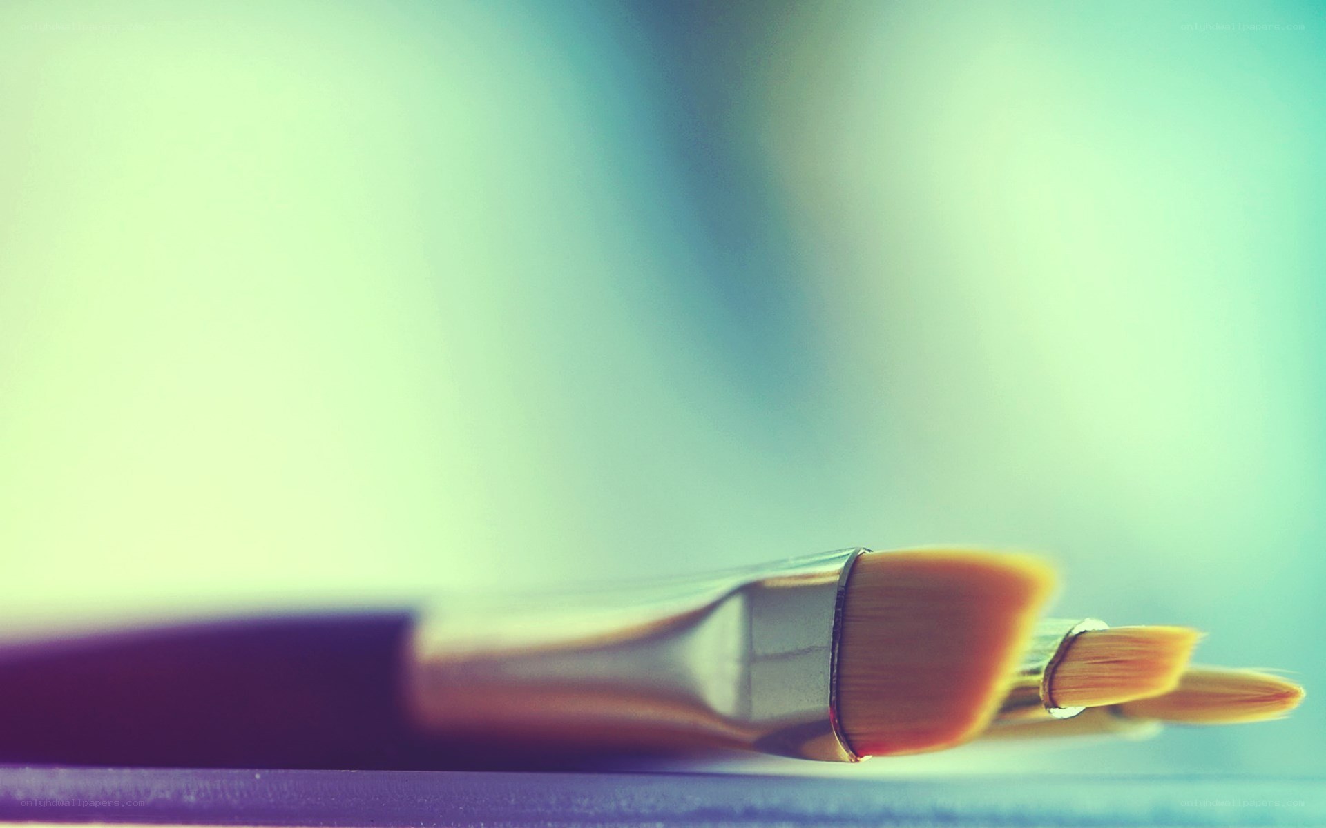Paintbrushes on a colorful surface