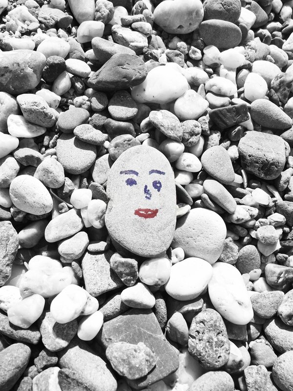 Painted face on a beach stone