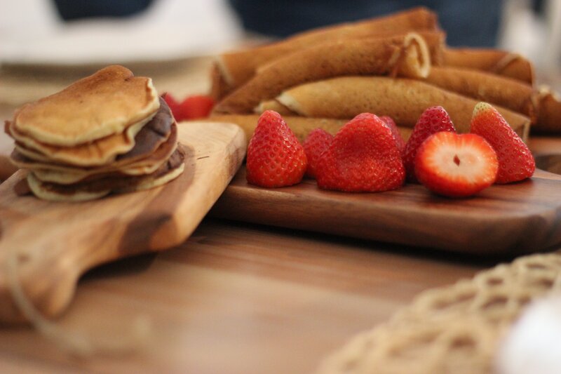 Pancakes and strawberries on wood