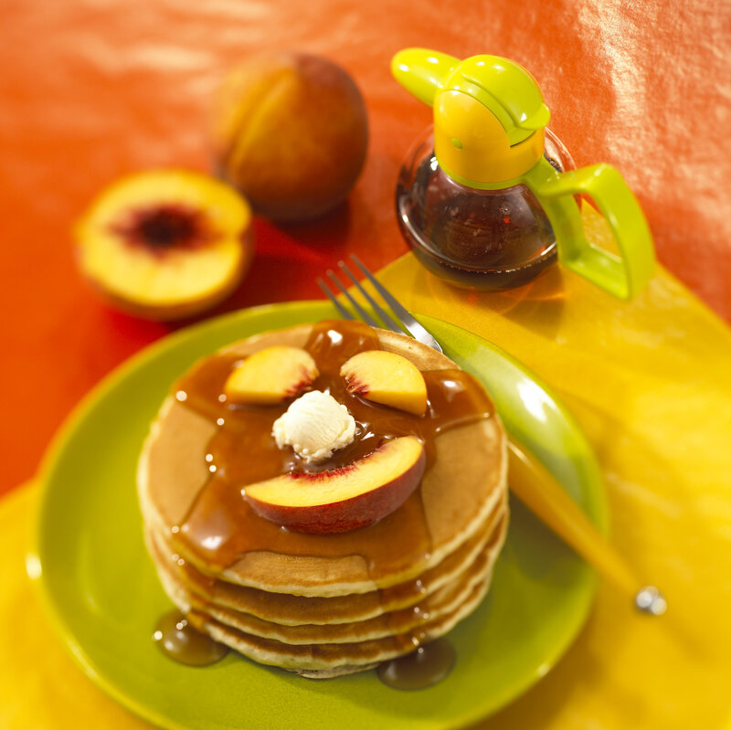 Pancakes with peaches and syrup