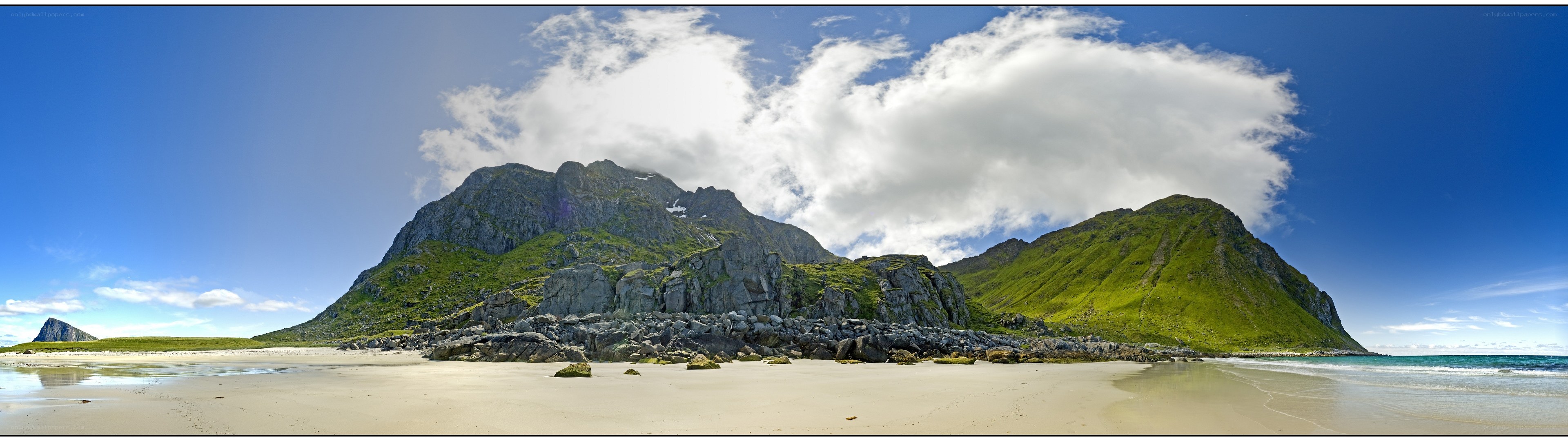 Panoramic beach with green mountains