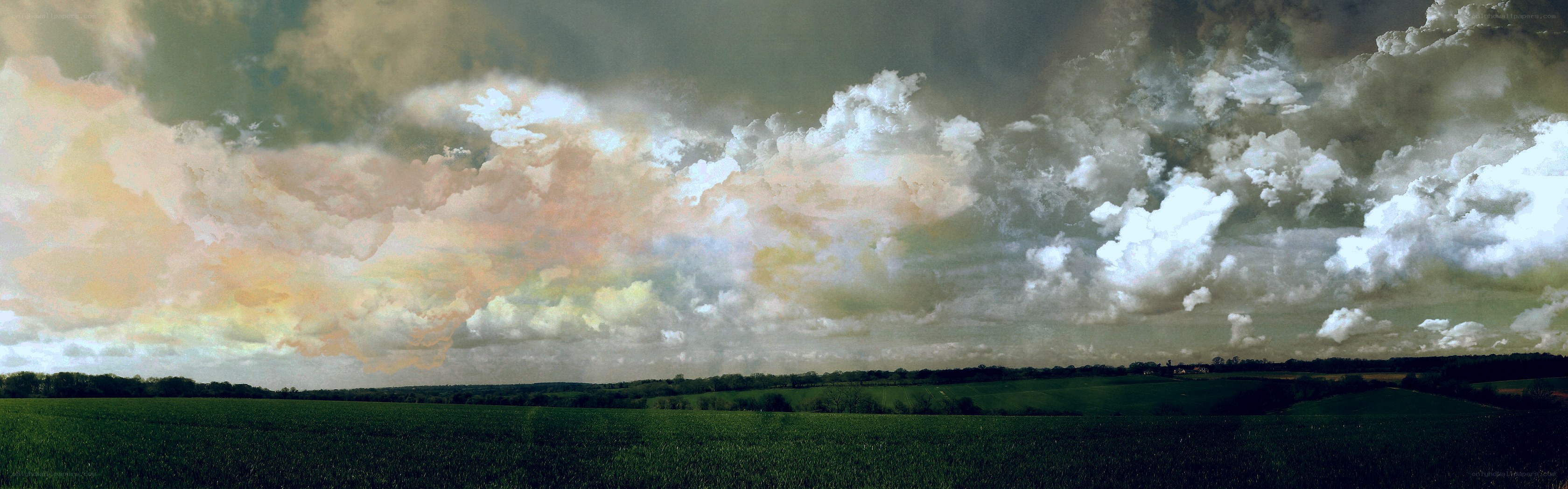 Panoramic sky over green fields