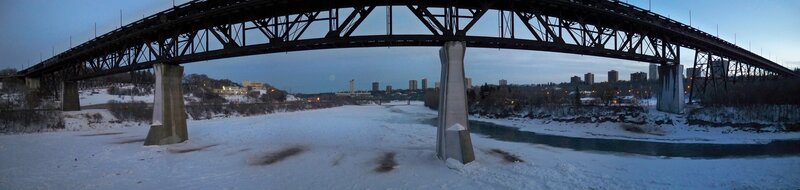 Panoramic view of a bridge over a frozen river