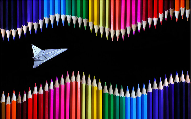 Paper Airplane Between Pencils