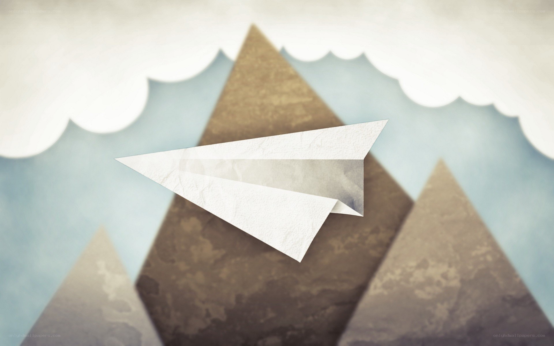 paper airplane flying over mountains