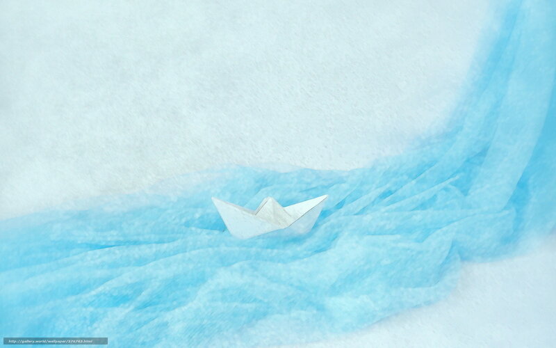 Paper boat on blue fabric