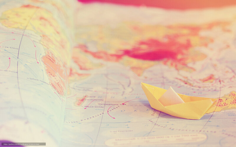 Paper boat on world map
