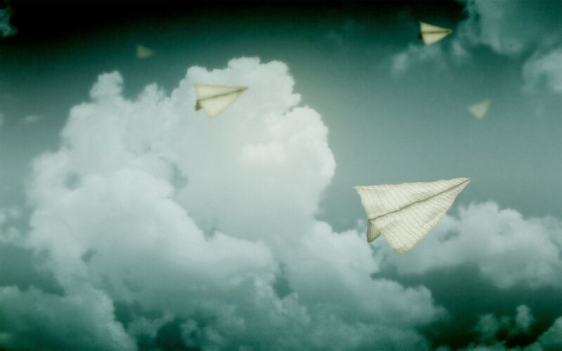 Paper planes in cloudy sky