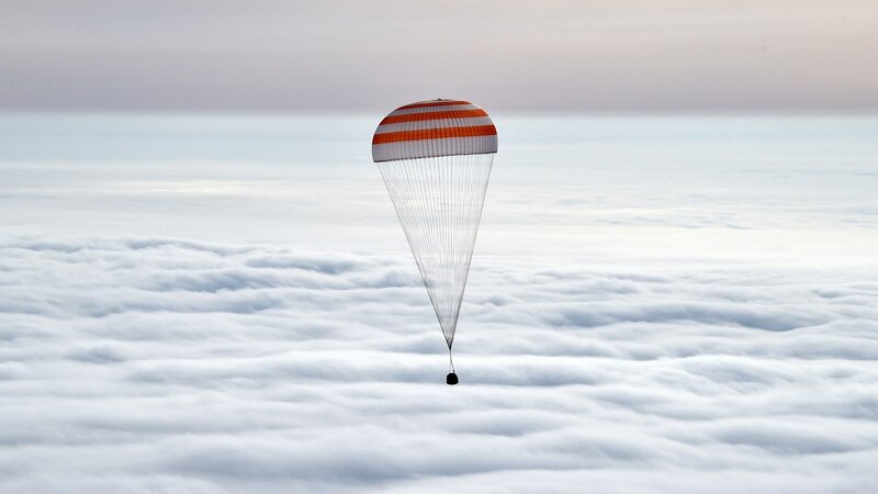 Parachute Descending over Clouds
