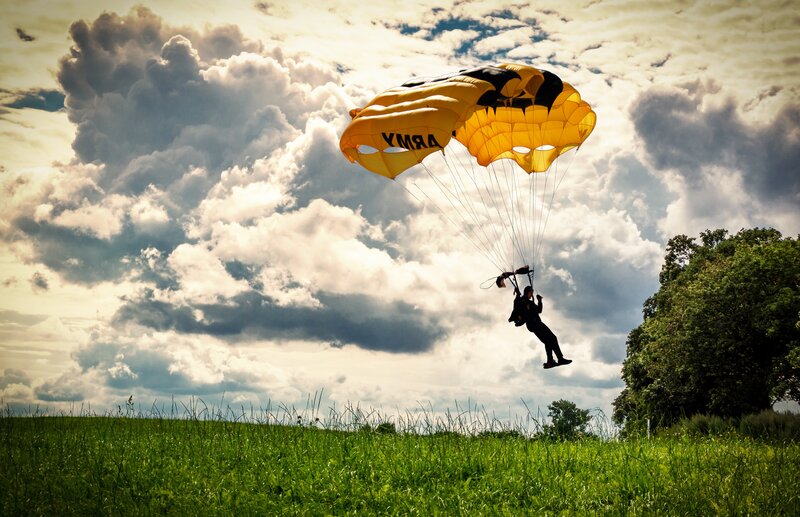 Parachutist descending over field