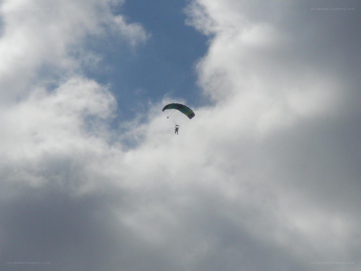 Parachutist in cloudy sky