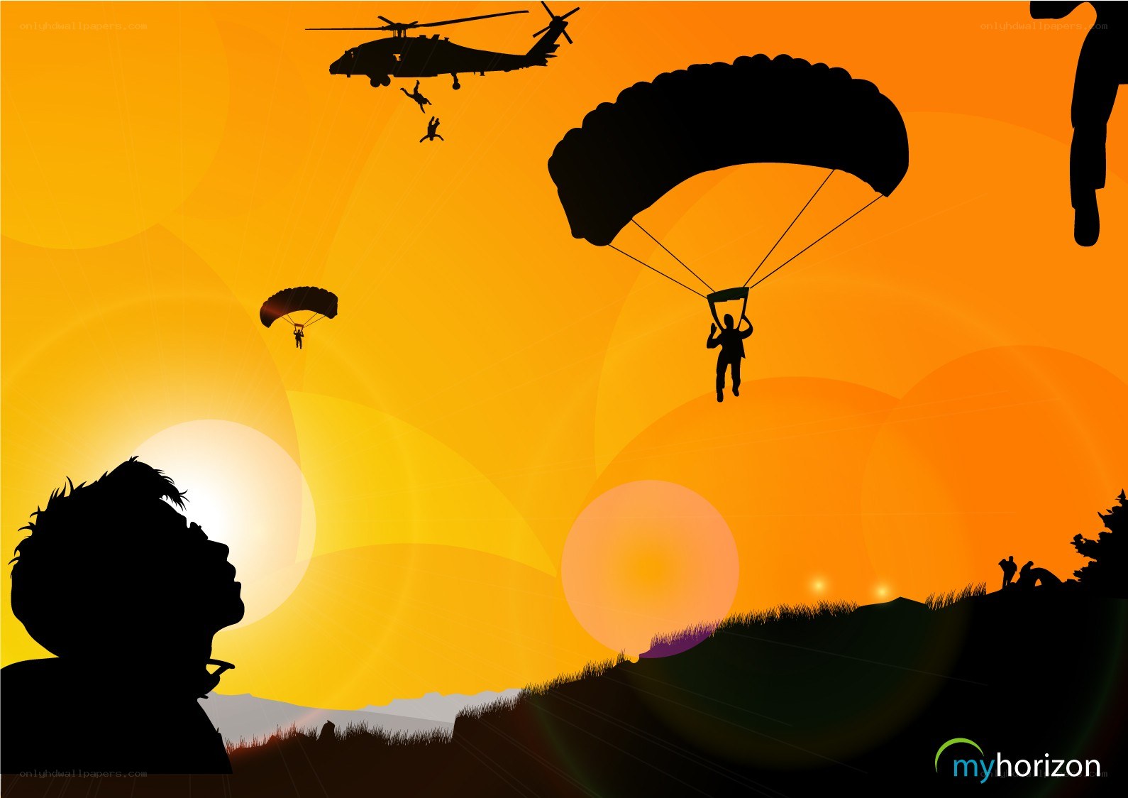 Parachutists descending at sunset