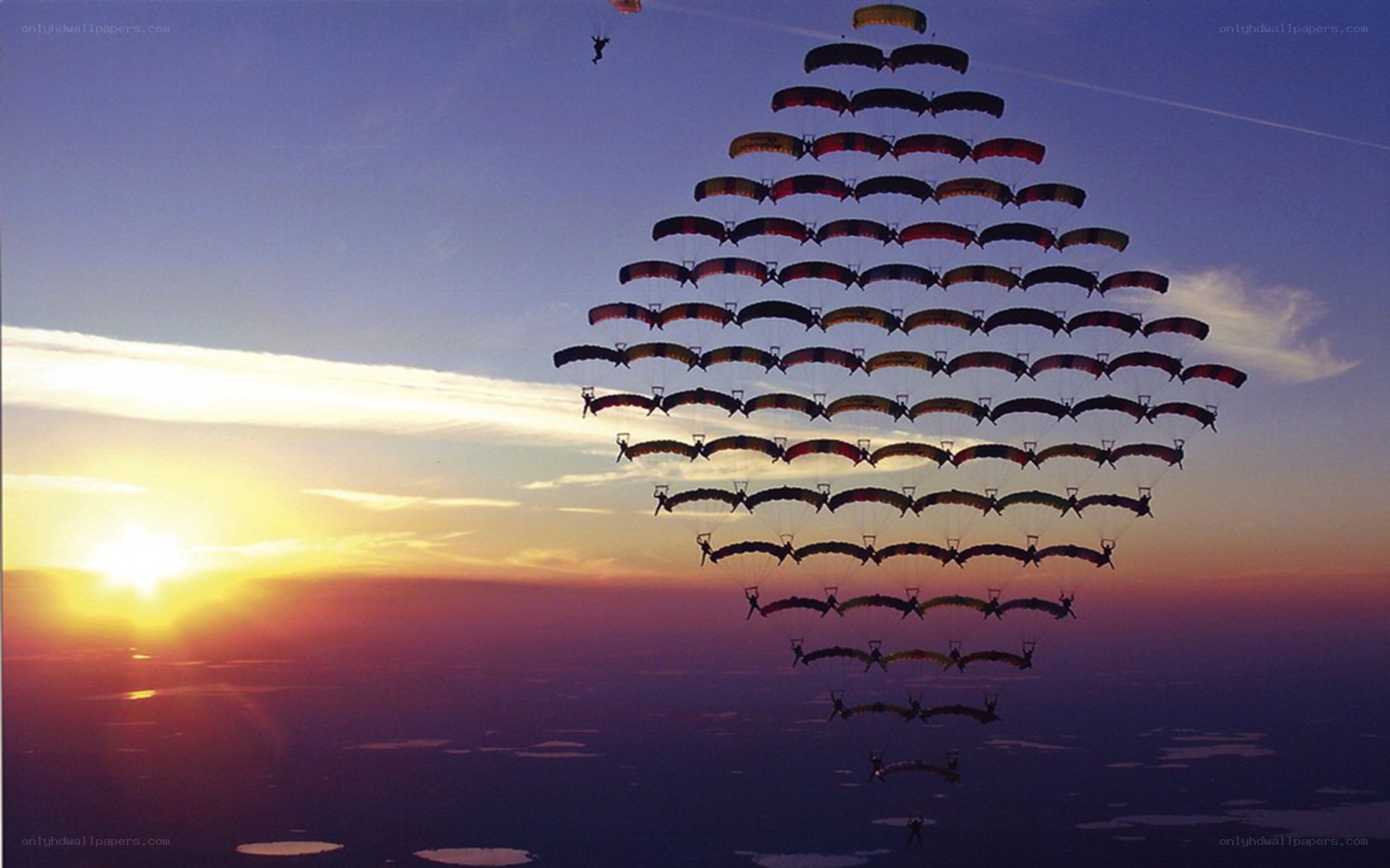 Parachutists in formation at sunset