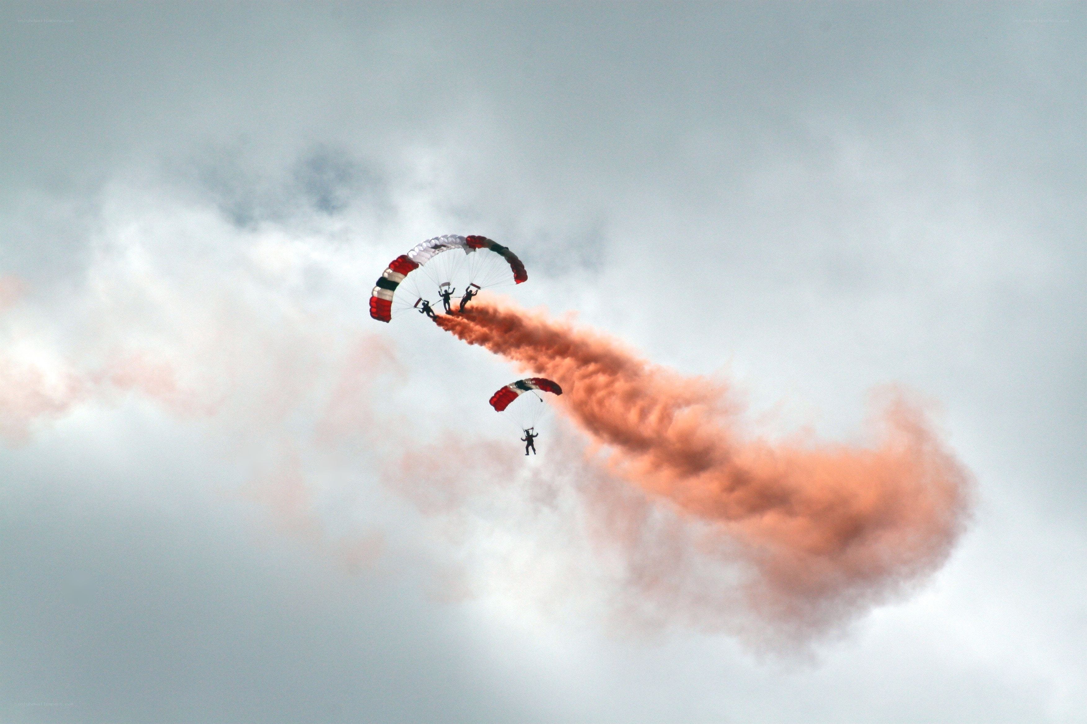 Parachutists with smoke trail