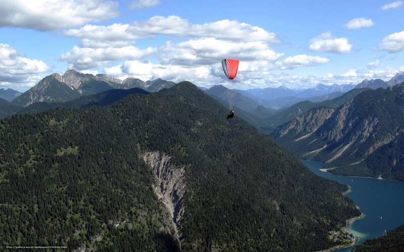 Paraglider over mountain lake
