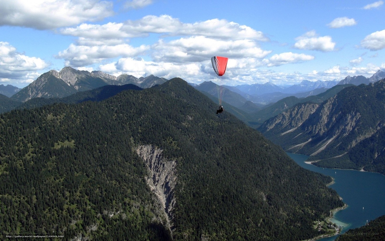 Paraglider over mountain lake