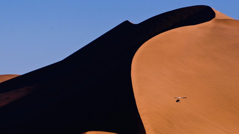 Paraglider over sand dunes