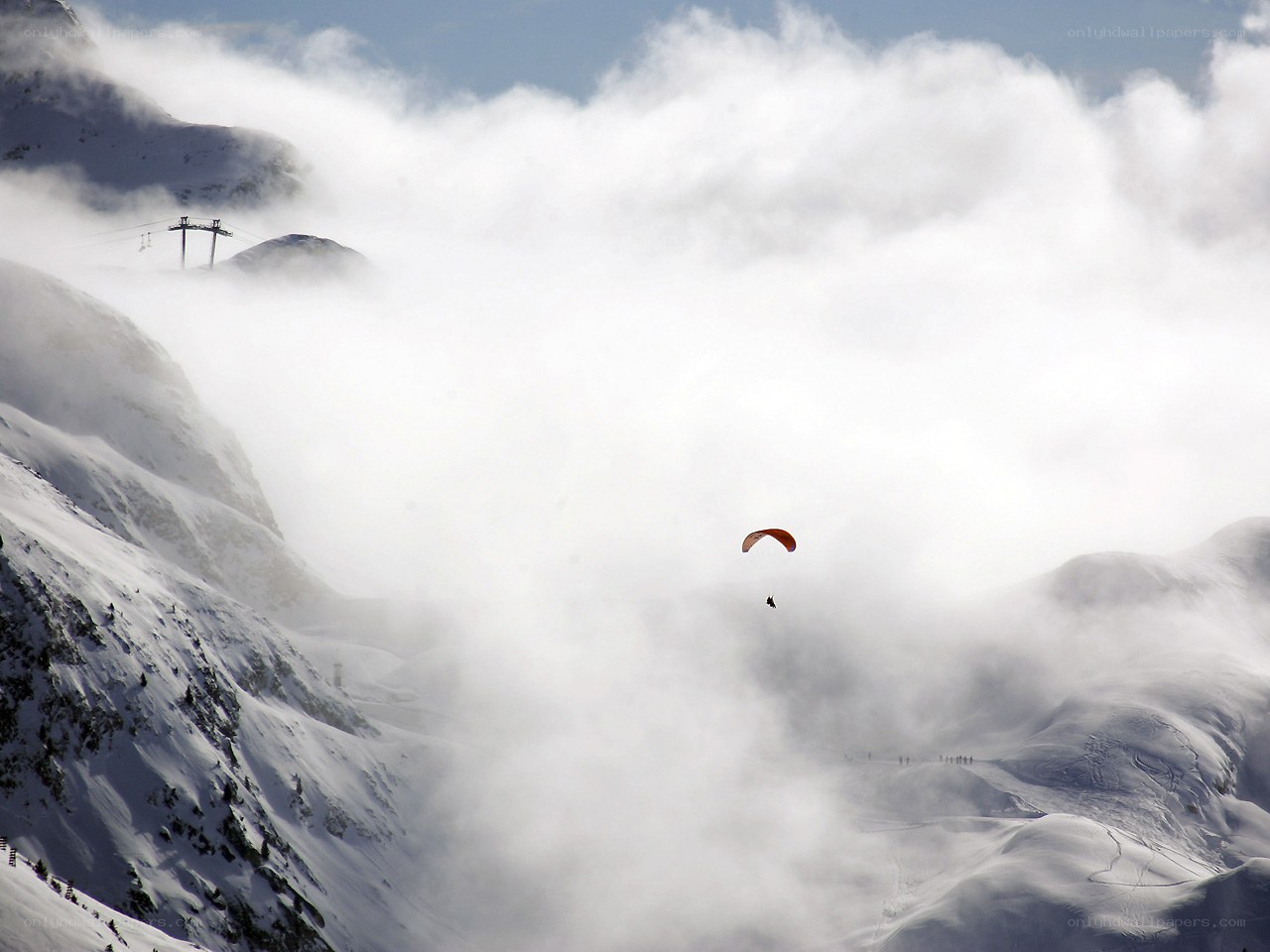 Paraglider over snowy mountains