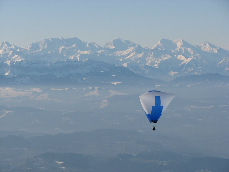 Paraglider over snowy mountains