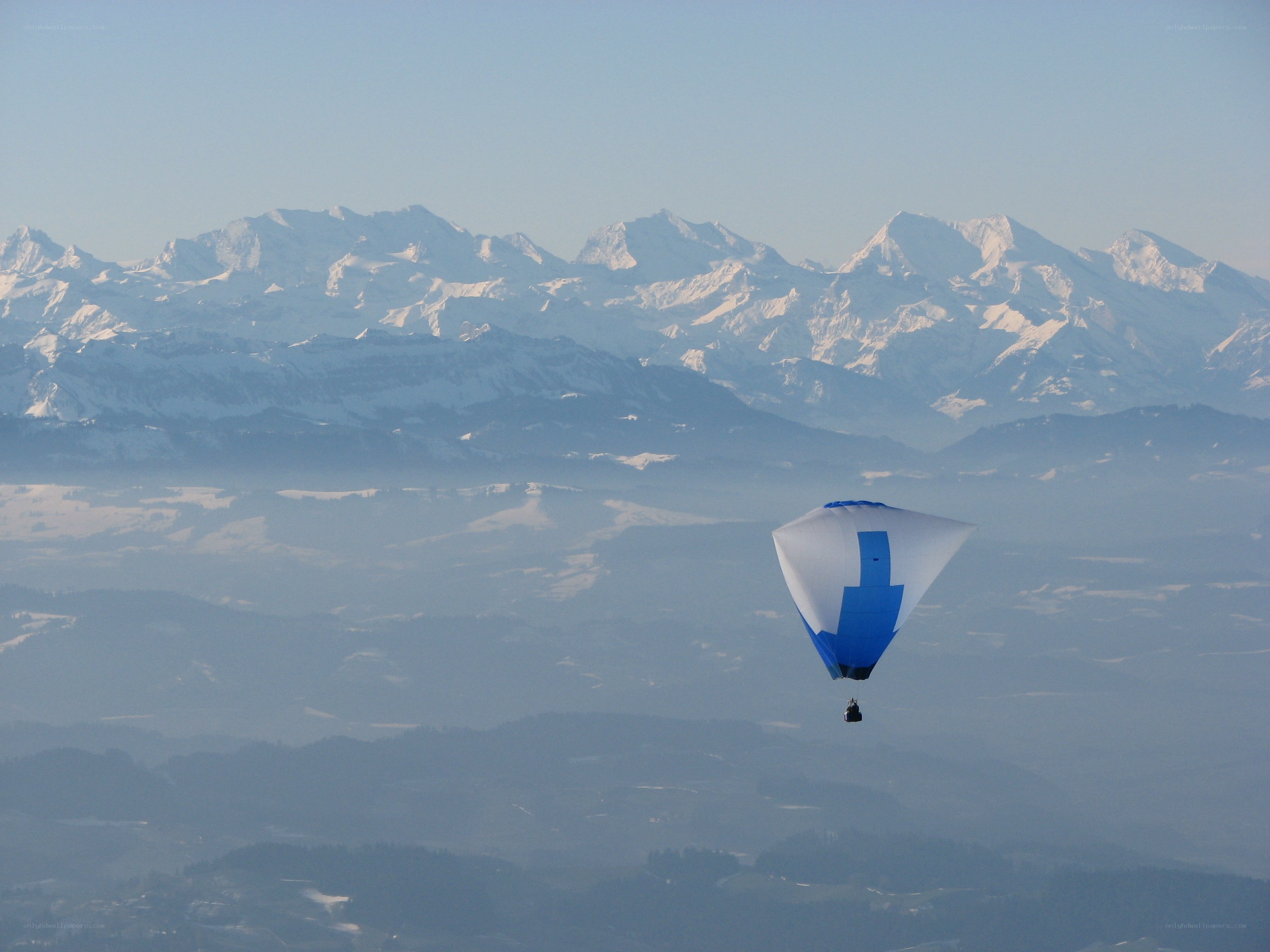 Paraglider over snowy mountains
