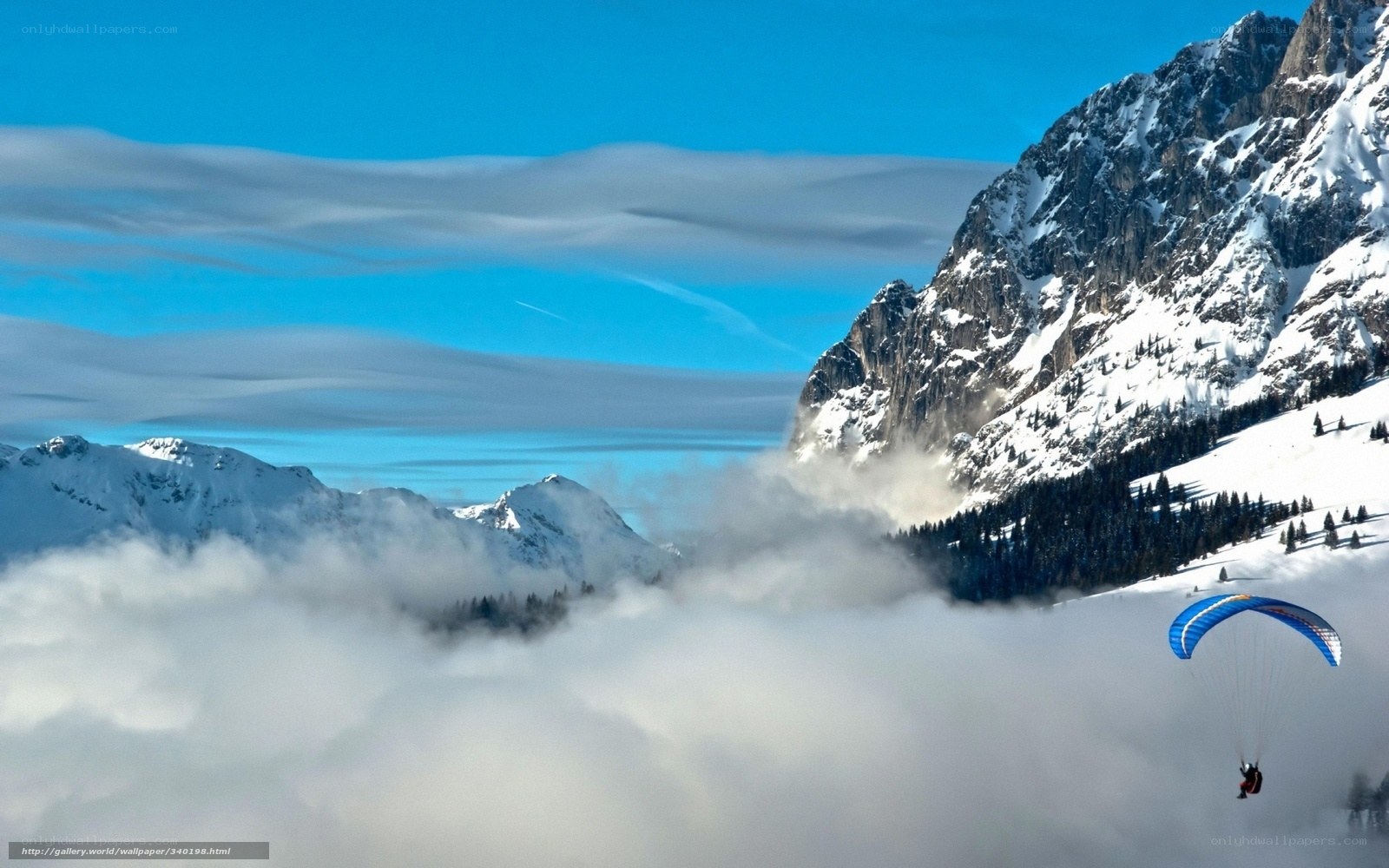 Paraglider over snowy mountains