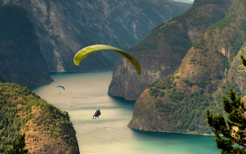 Paragliders over a fjord